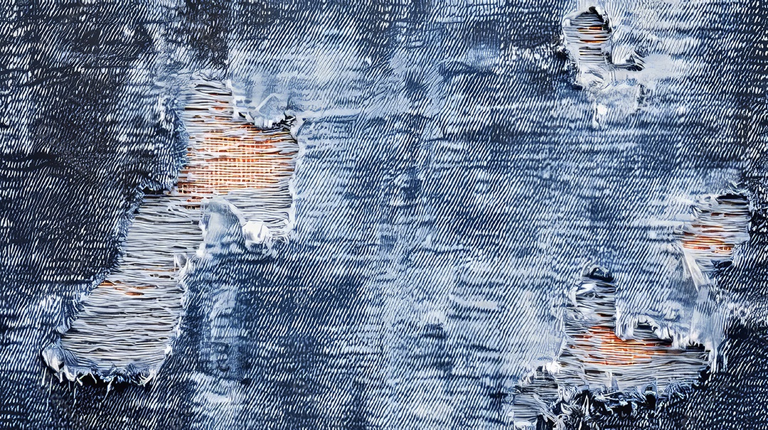 Textura e um tecido de jeans rasgado e desgastado.