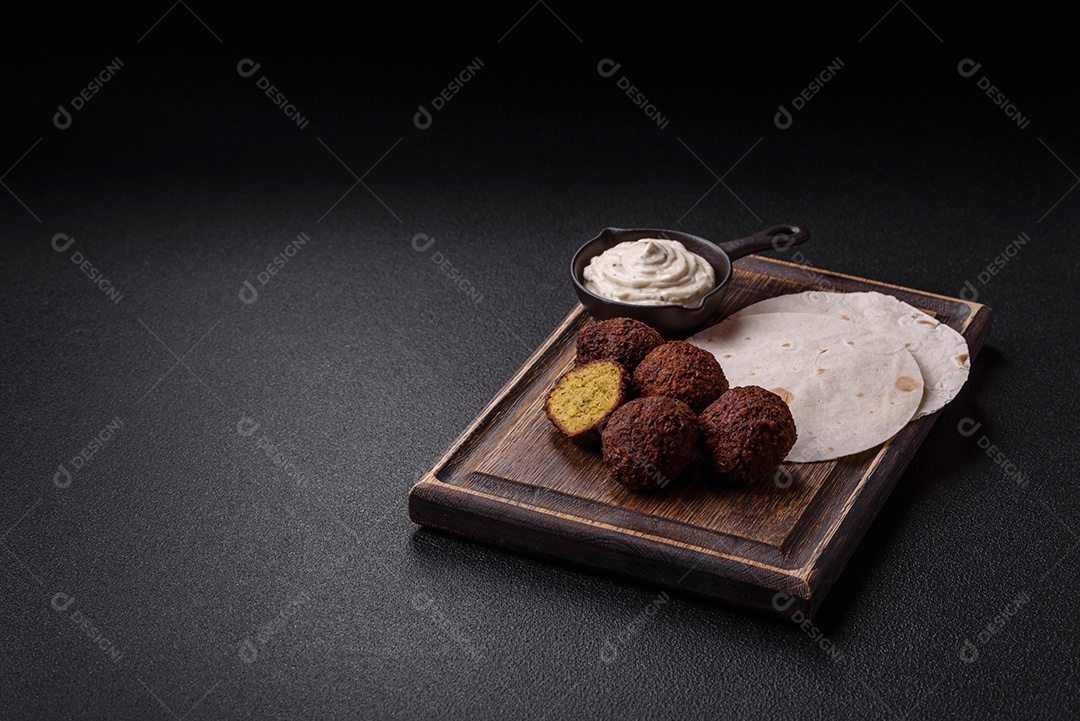 A imagem mostra faláfel, um bolinho frito popular no Oriente Médio feito de grão-de-bico ou fava moída