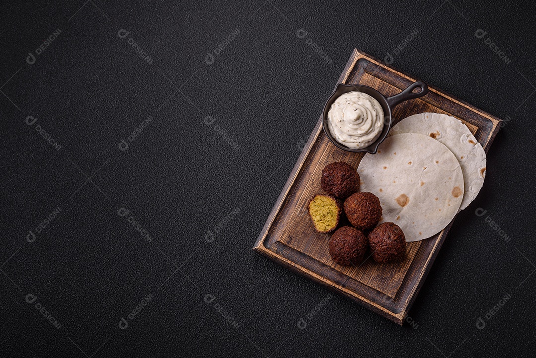 A imagem mostra faláfel, um bolinho frito popular no Oriente Médio feito de grão-de-bico ou fava moída