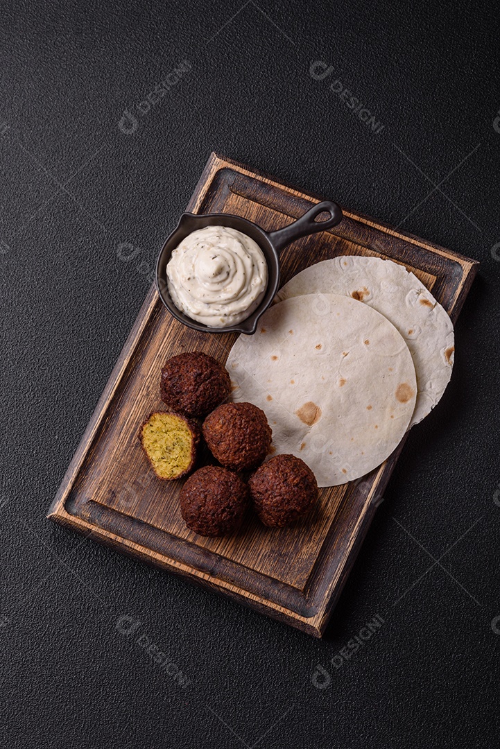 A imagem mostra faláfel, um bolinho frito popular no Oriente Médio feito de grão-de-bico ou fava moída