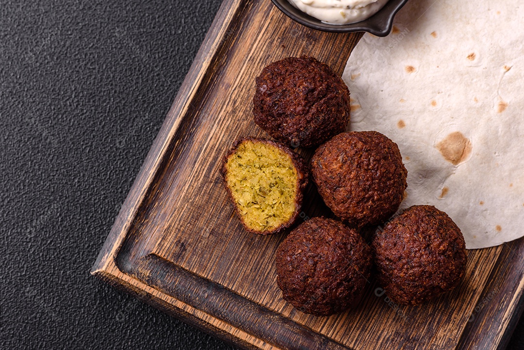 A imagem mostra faláfel, um bolinho frito popular no Oriente Médio feito de grão-de-bico ou fava moída