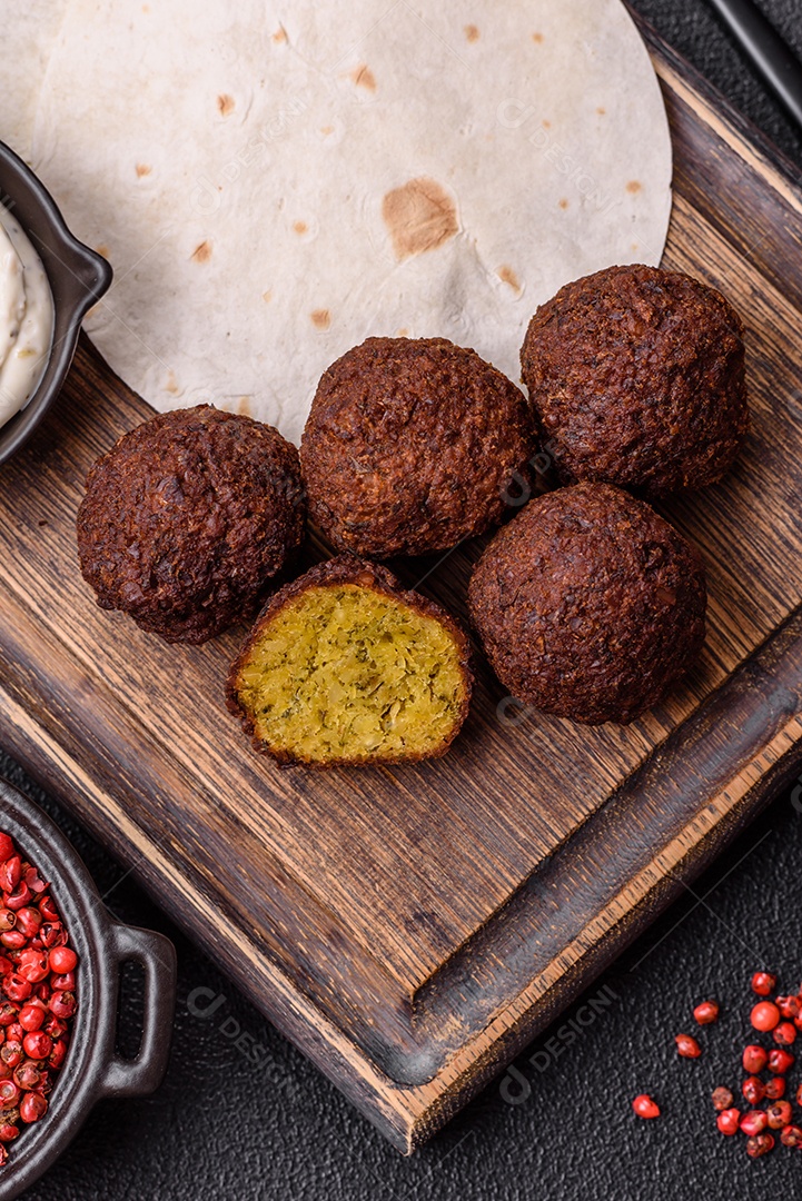 A imagem mostra faláfel, um bolinho frito popular no Oriente Médio feito de grão-de-bico ou fava moída