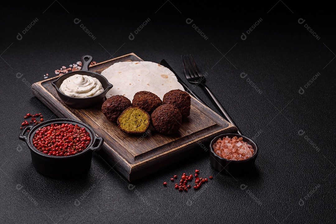 A imagem mostra faláfel, um bolinho frito popular no Oriente Médio feito de grão-de-bico ou fava moída