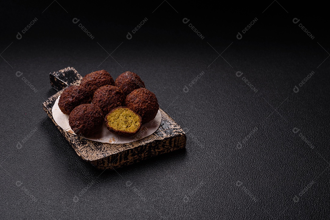 A imagem mostra bolinhos de faláfel servidos em um pão achatado.