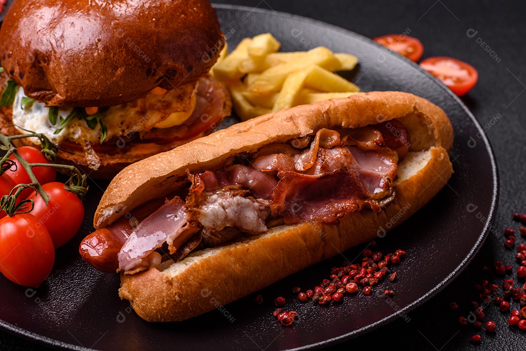 A imagem mostra um prato com um cachorro-quente e um hambúrguer, ambos servidos com batatas fritas e tomates cereja