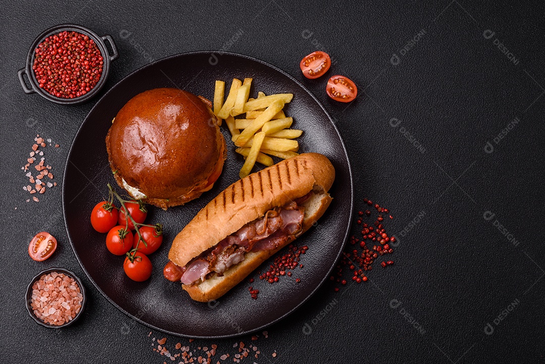 A imagem mostra um prato com um cachorro-quente e um hambúrguer, ambos servidos com batatas fritas e tomates cereja