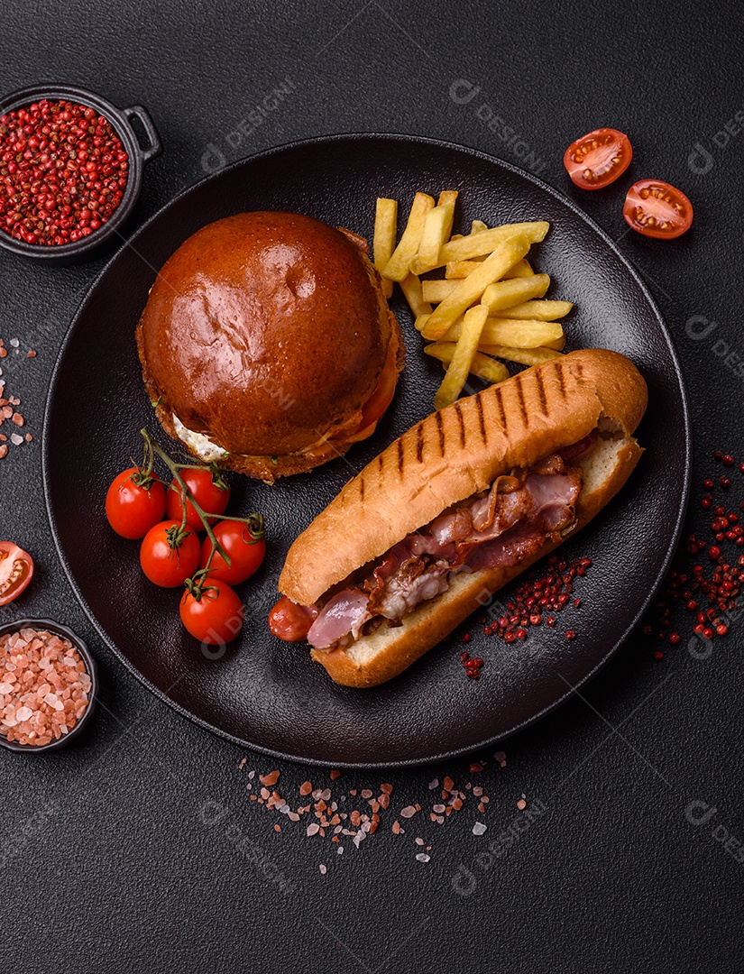A imagem mostra um prato com um cachorro-quente e um hambúrguer, ambos servidos com batatas fritas e tomates cereja
