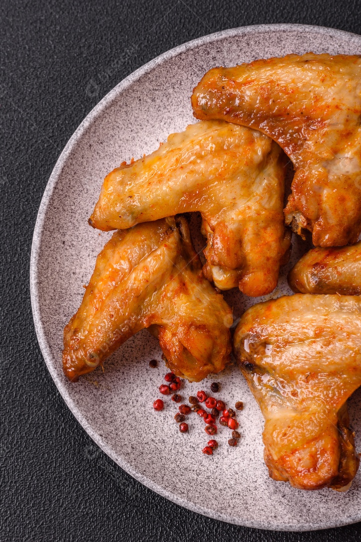 A imagem mostra pedaços de frango frito ou assado, possivelmente asas ou coxas da asa, servidos como aperitivo ou refeição