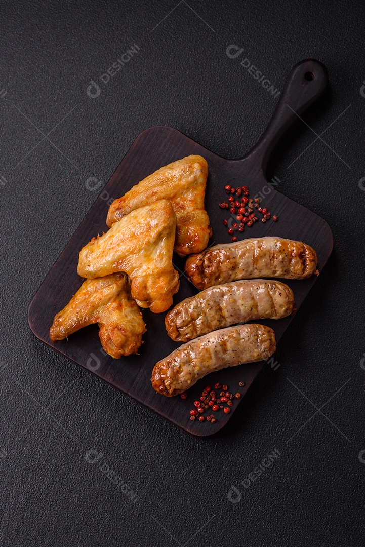 Três linguiças salsichas grelhadas são apresentadas em um prato, com temperos e tomates-cereja cortados.