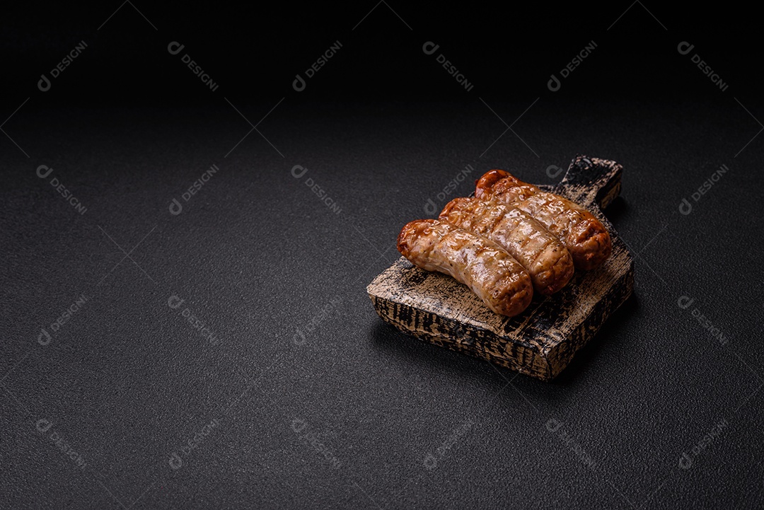 Três linguiças ou salsichas grelhadas são apresentadas em um prato, com temperos e tomates-cereja cortados.