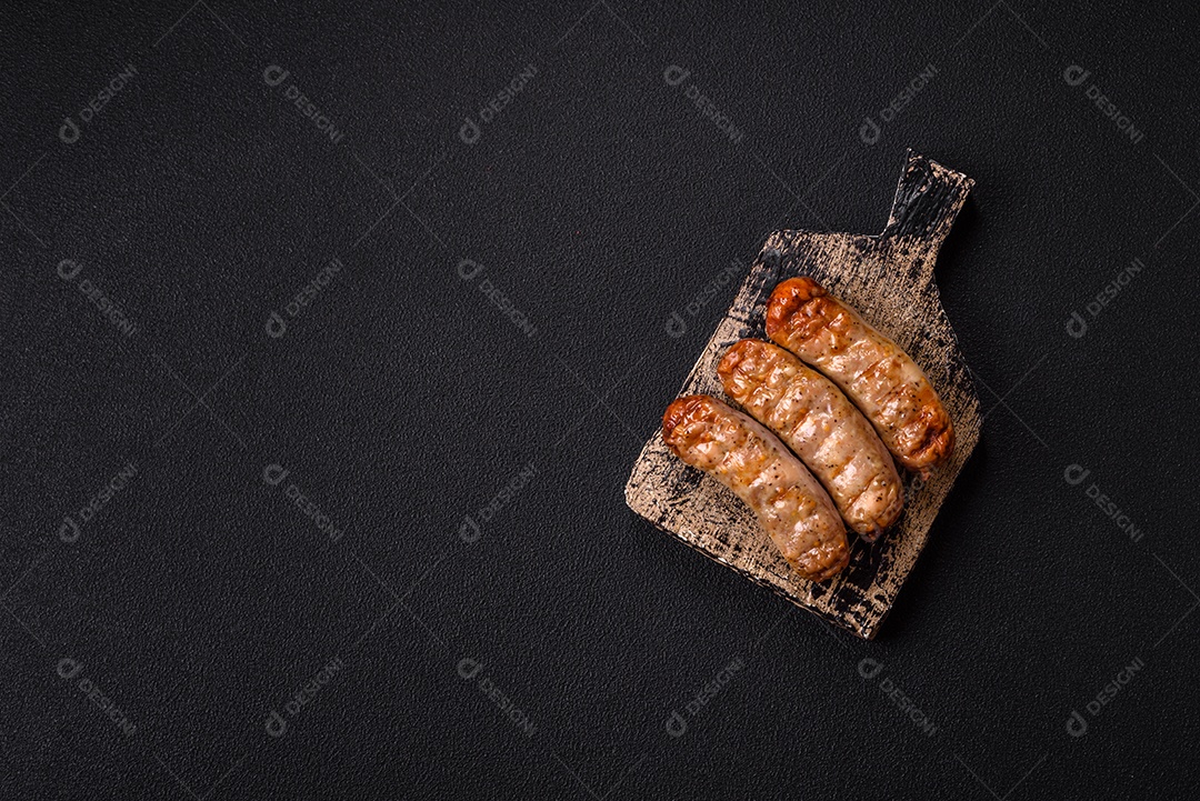 Três linguiças ou salsichas grelhadas são apresentadas em um prato, com temperos e tomates-cereja cortados.