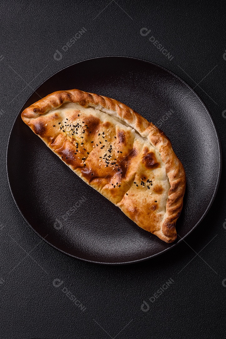 A imagem mostra um cheburek, um tipo de pastel frito em formato de meia-lua