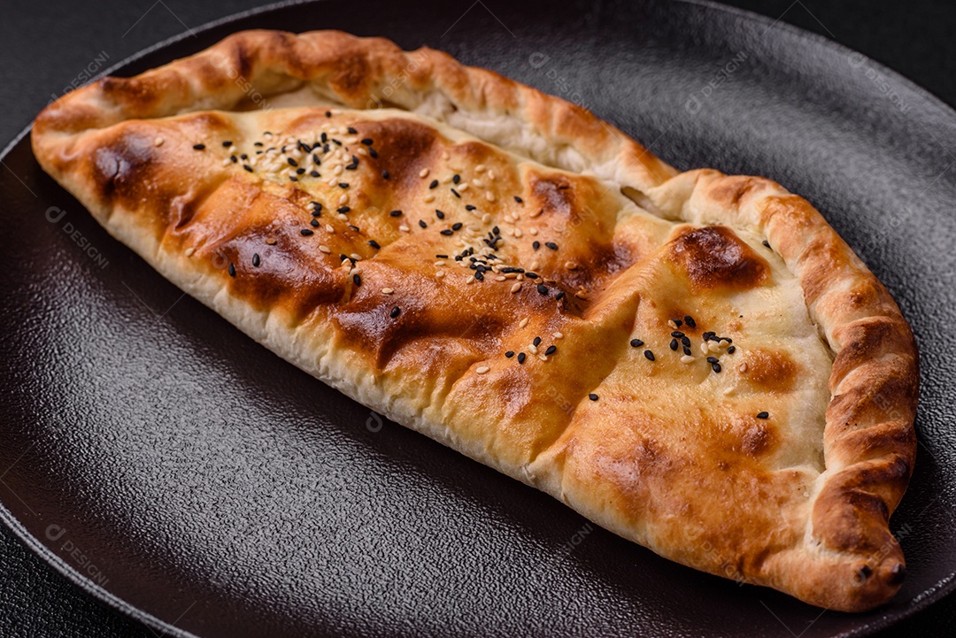 A imagem mostra um cheburek, um tipo de pastel frito em formato de meia-lua