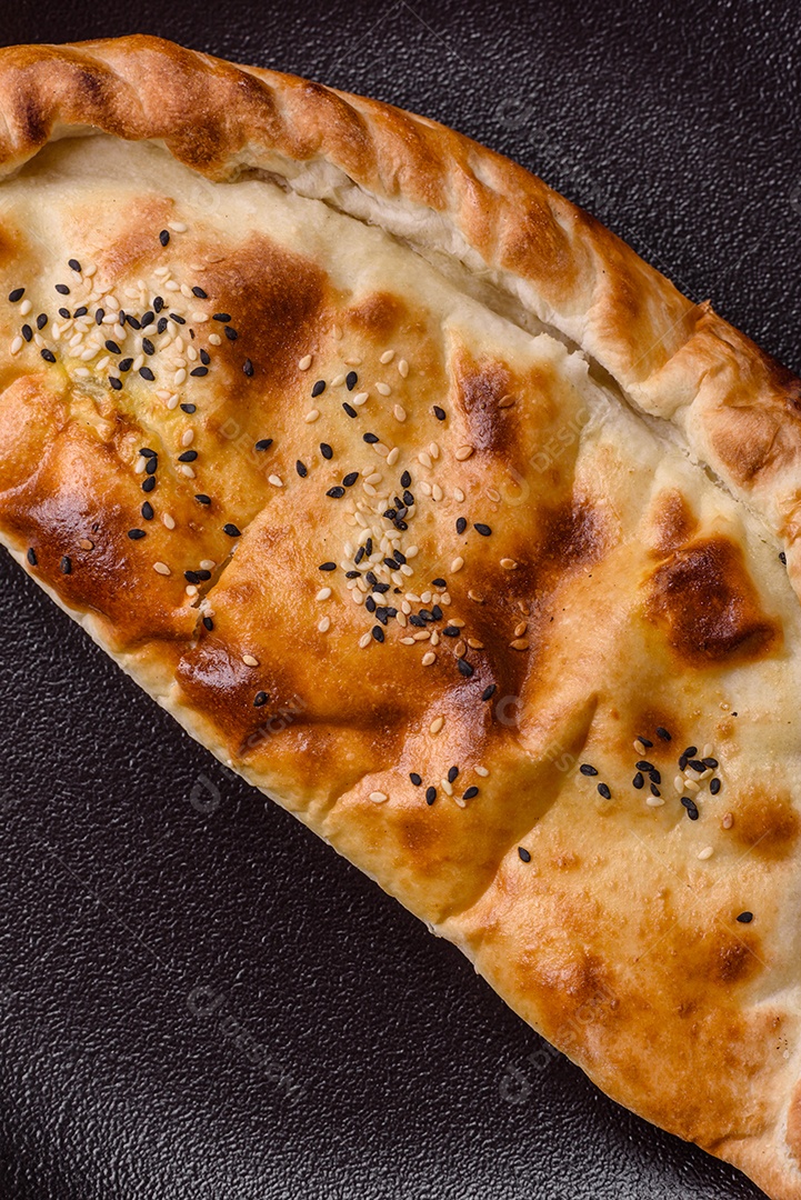 A imagem mostra um cheburek, um tipo de pastel frito em formato de meia-lua