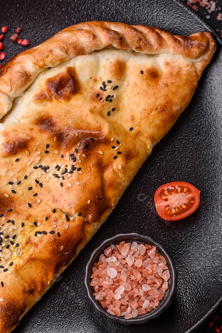 A imagem mostra um cheburek, um tipo de pastel frito em formato de meia-lua