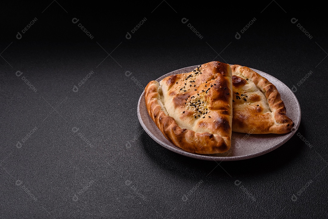 A imagem mostra um cheburek, um tipo de pastel frito em formato de meia-lua