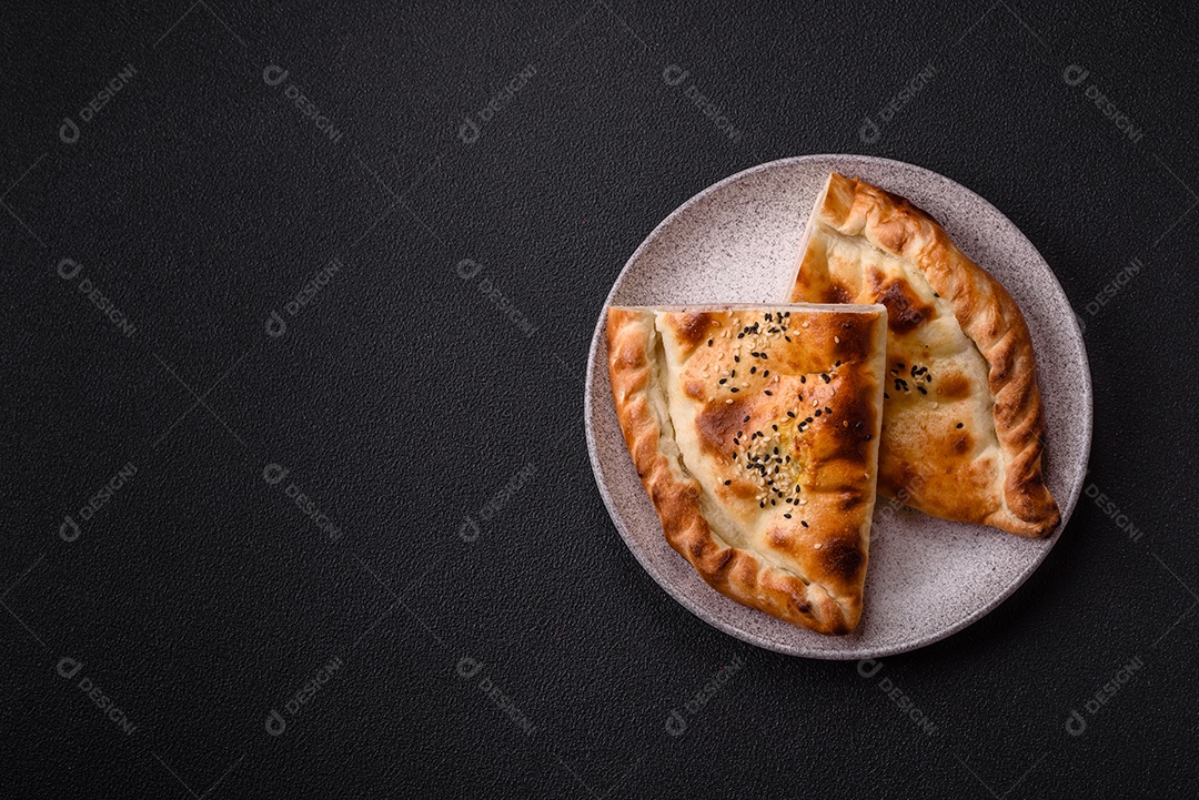 A imagem mostra um cheburek, um tipo de pastel frito em formato de meia-lua