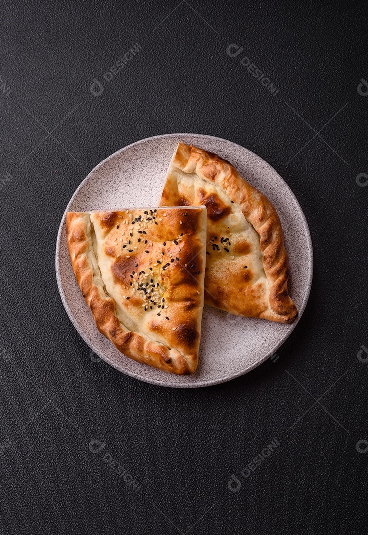 A imagem mostra um cheburek, um tipo de pastel frito em formato de meia-lua