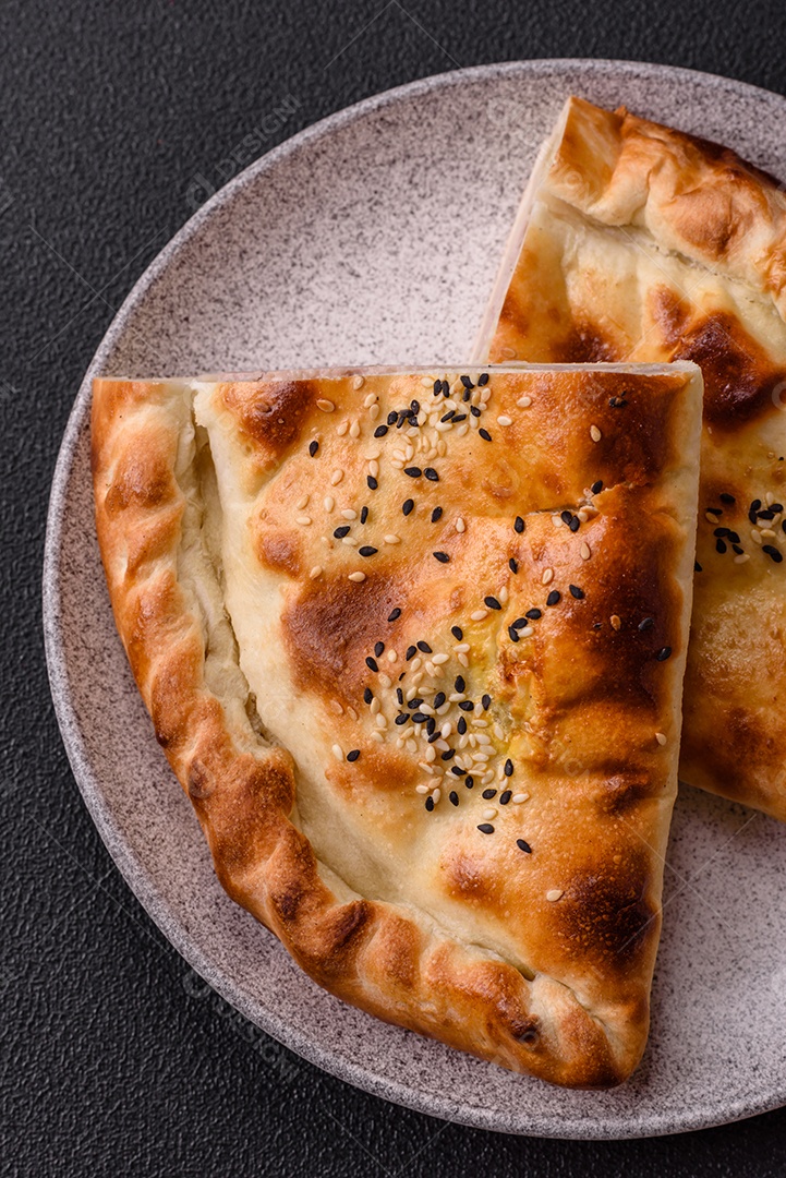 A imagem mostra um cheburek, um tipo de pastel frito em formato de meia-lua