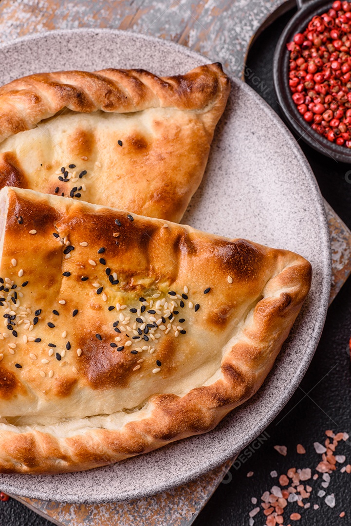 A imagem mostra um cheburek, um tipo de pastel frito em formato de meia-lua