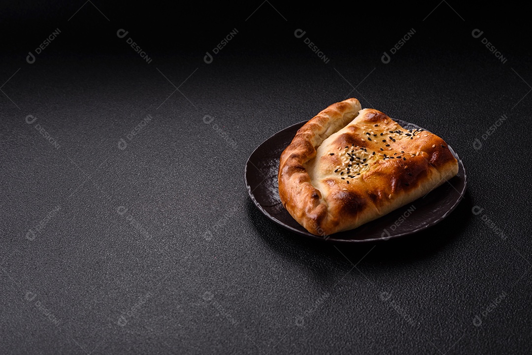 A imagem mostra um cheburek, um tipo de pastel frito em formato de meia-lua