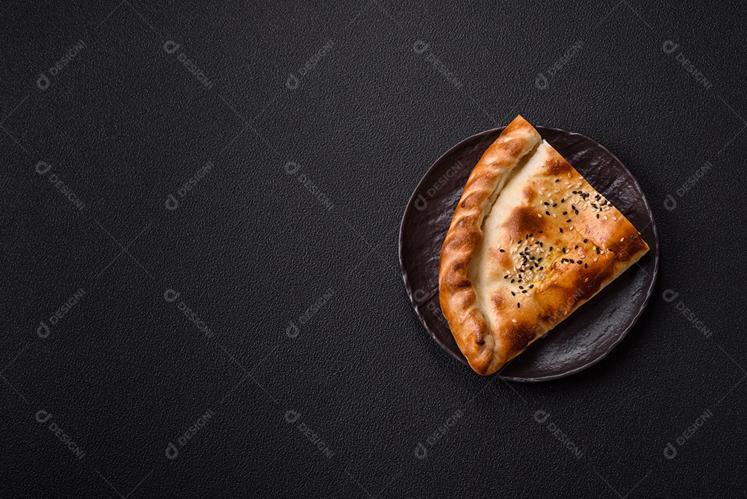 A imagem mostra um cheburek, um tipo de pastel frito em formato de meia-lua