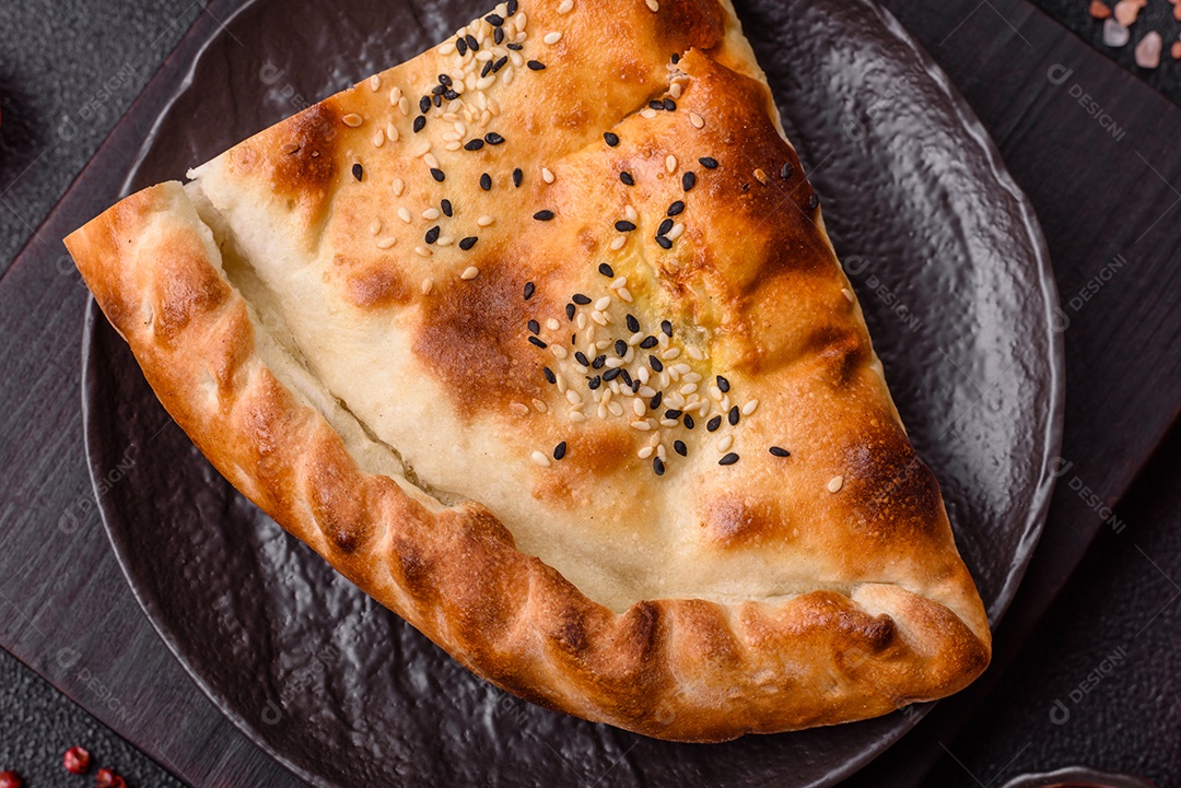 A imagem mostra um cheburek, um tipo de pastel frito em formato de meia-lua