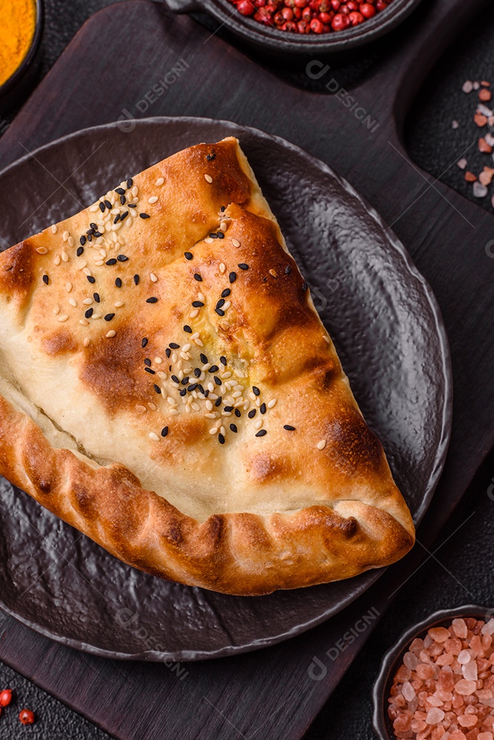 A imagem mostra um cheburek, um tipo de pastel frito em formato de meia-lua