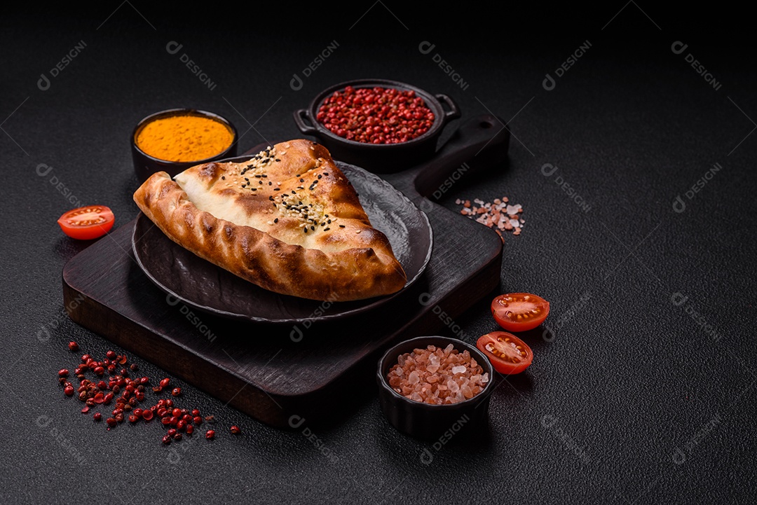 A imagem mostra um cheburek, um tipo de pastel frito em formato de meia-lua