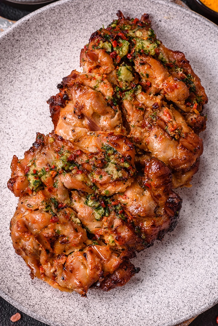 A imagem mostra um prato de shawarma de frango. O shawarma é um prato popular do Oriente Médio que consiste em carne assada em um espeto vertical e servida em fatias finas