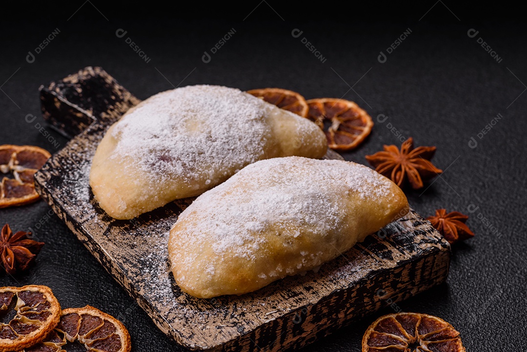 A imagem mostra biscoitos ou pastéis polvilhados com açúcar de confeiteiro, que podem ser semelhantes ao pastel de carne com açúcar