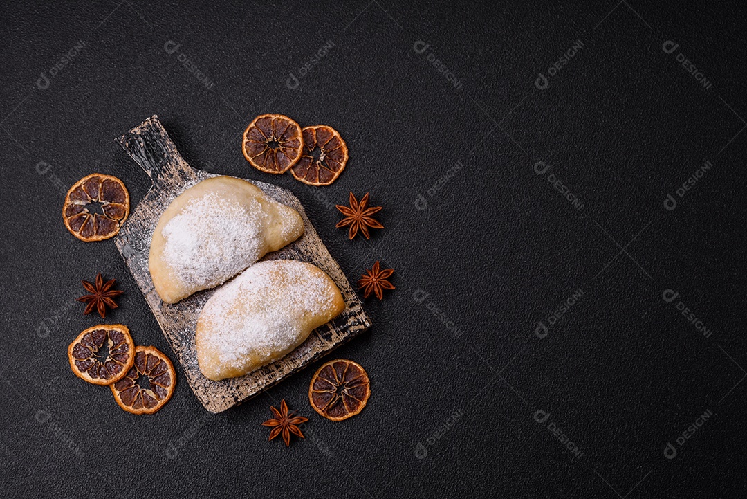 A imagem mostra biscoitos ou pastéis polvilhados com açúcar de confeiteiro, que podem ser semelhantes ao pastel de carne com açúcar