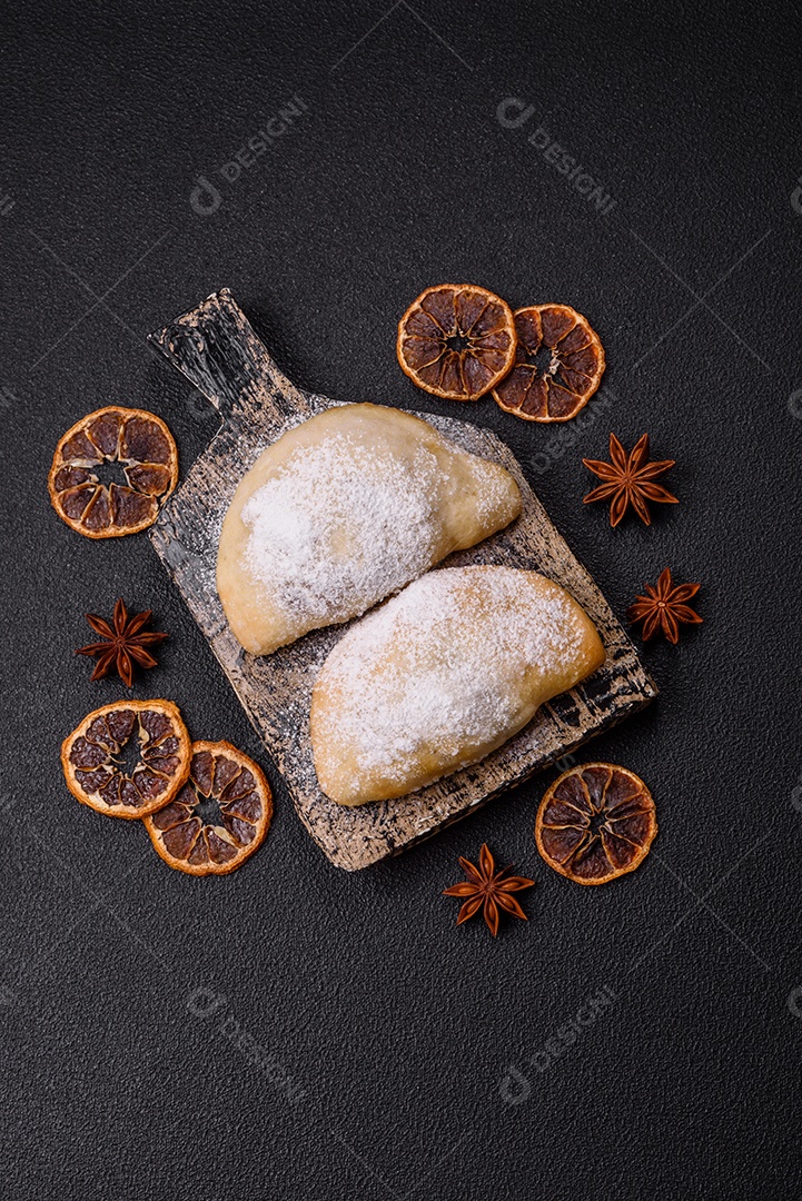 A imagem mostra biscoitos ou pastéis polvilhados com açúcar de confeiteiro, que podem ser semelhantes ao pastel de carne com açúcar