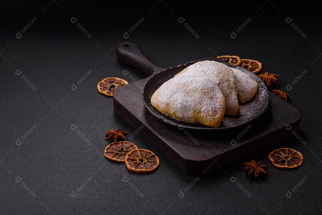 A imagem mostra biscoitos ou pastéis polvilhados com açúcar de confeiteiro, que podem ser semelhantes ao pastel de carne com açúcar