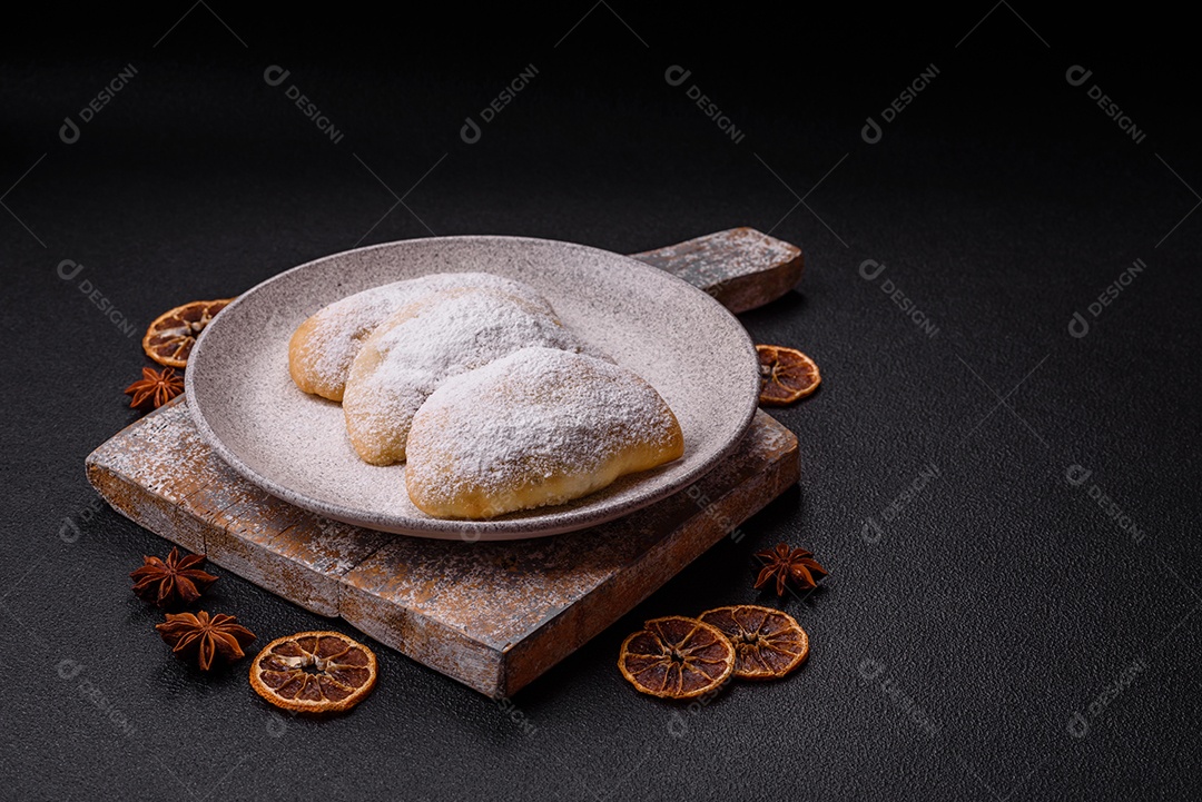 A imagem mostra biscoitos ou pastéis polvilhados com açúcar de confeiteiro, que podem ser semelhantes ao pastel de carne com açúcar