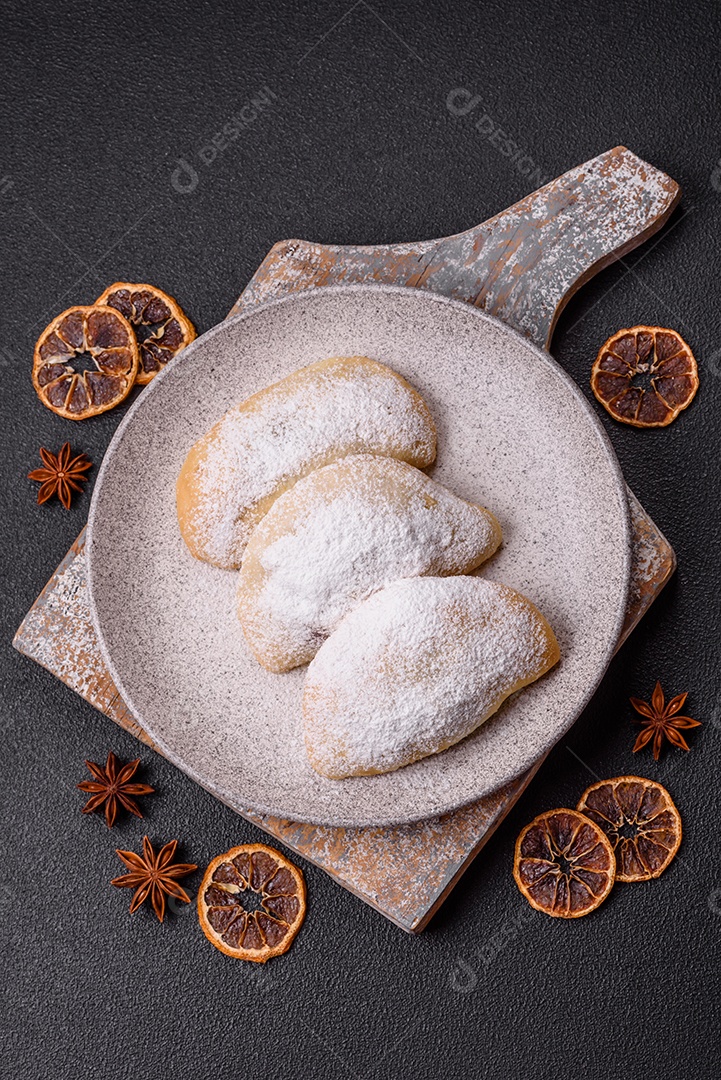 A imagem mostra biscoitos ou pastéis polvilhados com açúcar de confeiteiro, que podem ser semelhantes ao pastel de carne com açúcar