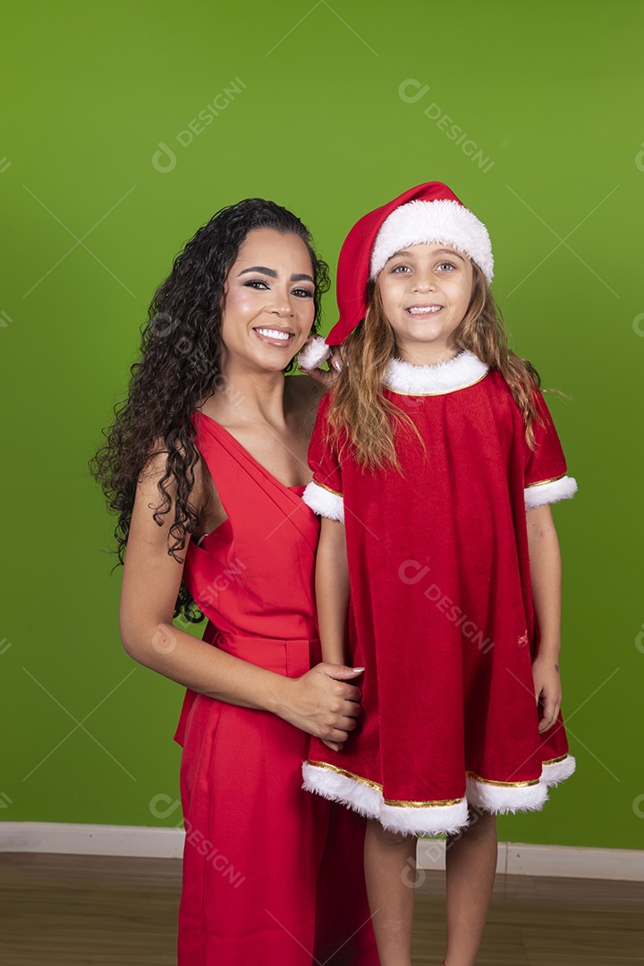 Linda mulher jovem morena ao lado de bonita garotinha usando roupas típicas natalina