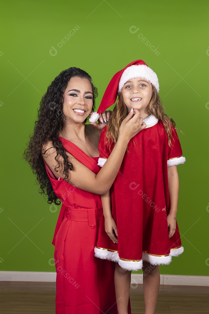 Linda mulher jovem morena ao lado de bonita garotinha usando roupas típicas natalina