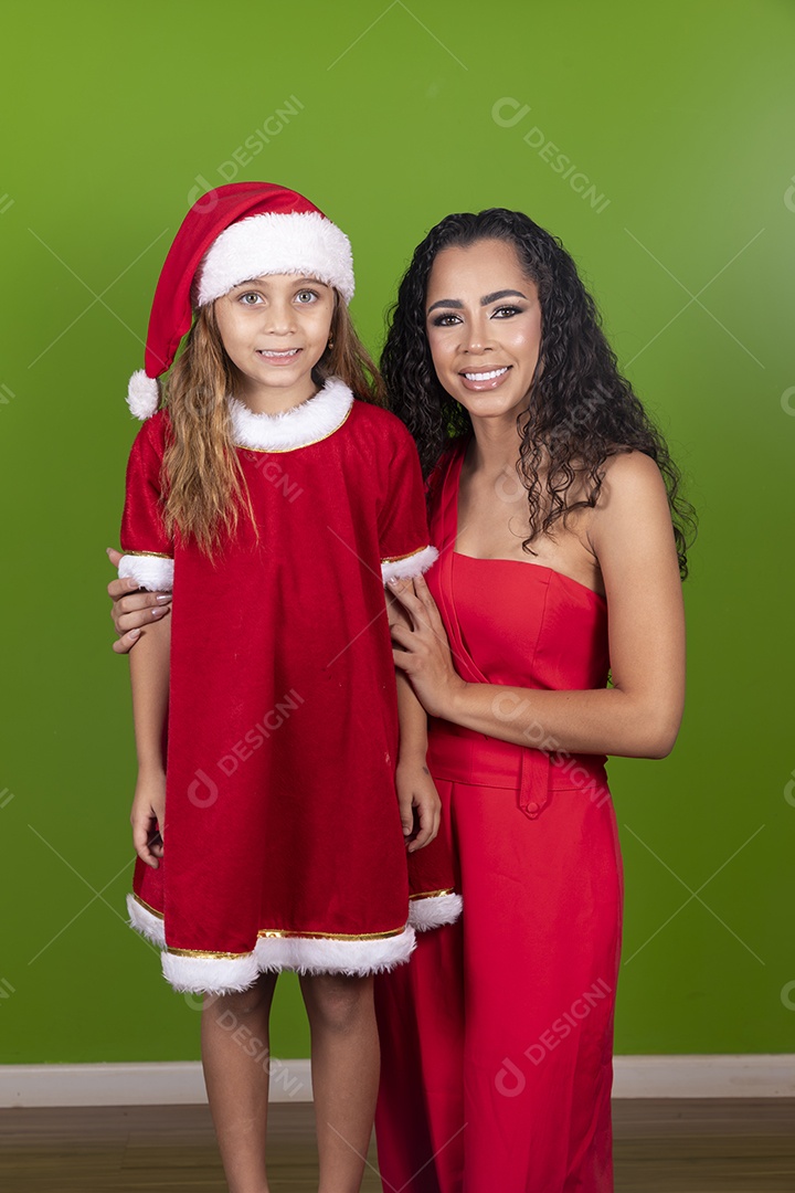 Linda mulher jovem morena ao lado de bonita garotinha usando roupas típicas natalina