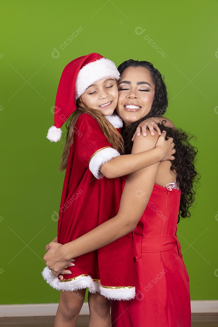 Linda mulher jovem morena ao lado de bonita garotinha usando roupas típicas natalina