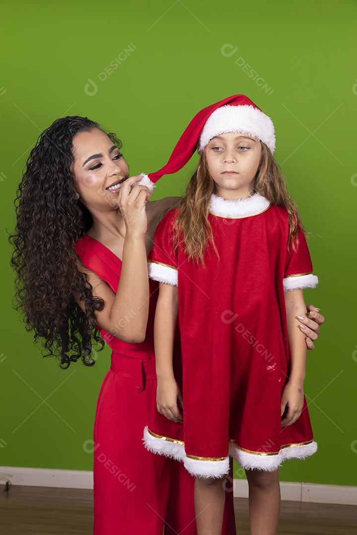 Linda mulher jovem morena ao lado de bonita garotinha usando roupas típicas natalina