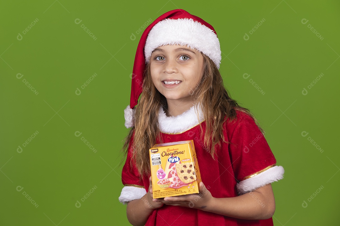 Linda garotinha feliz usando gorro do papai noel segurando Panetone