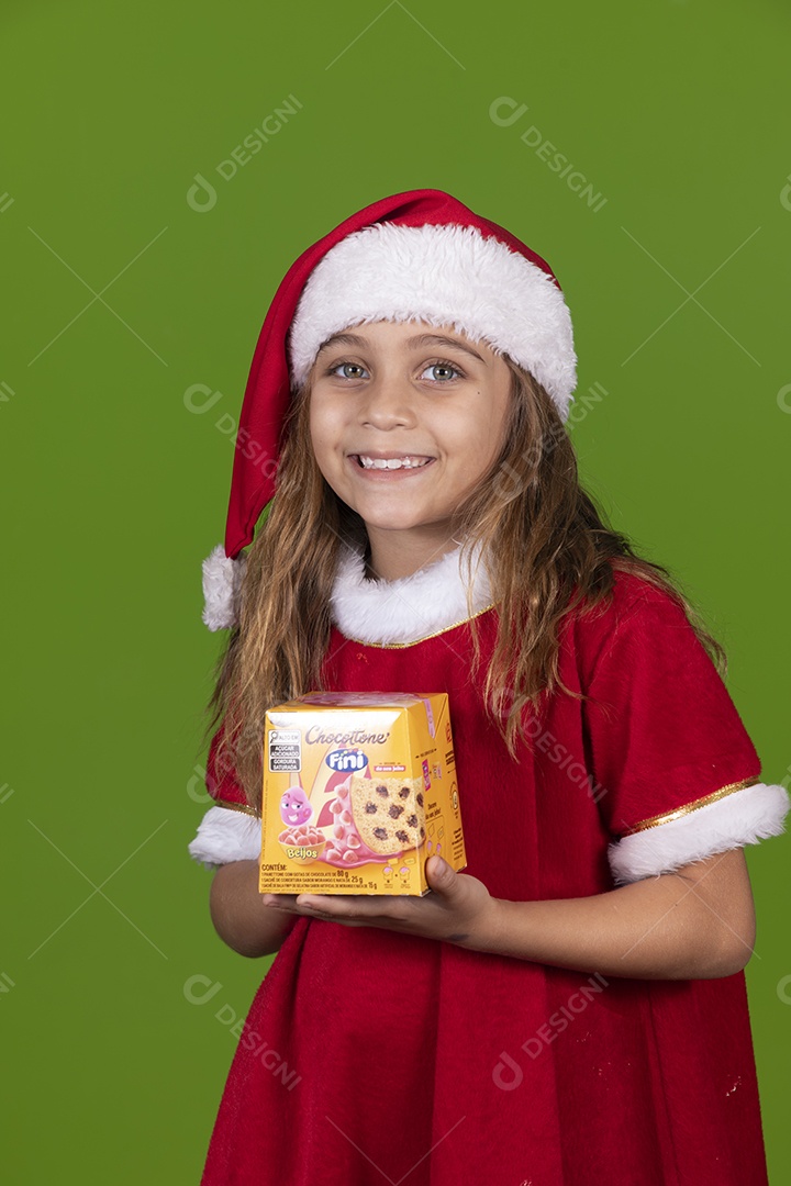 Linda garotinha feliz usando gorro do papai noel segurando Panetone