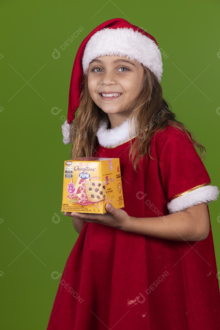 Linda garotinha feliz usando gorro do papai noel segurando Panetone